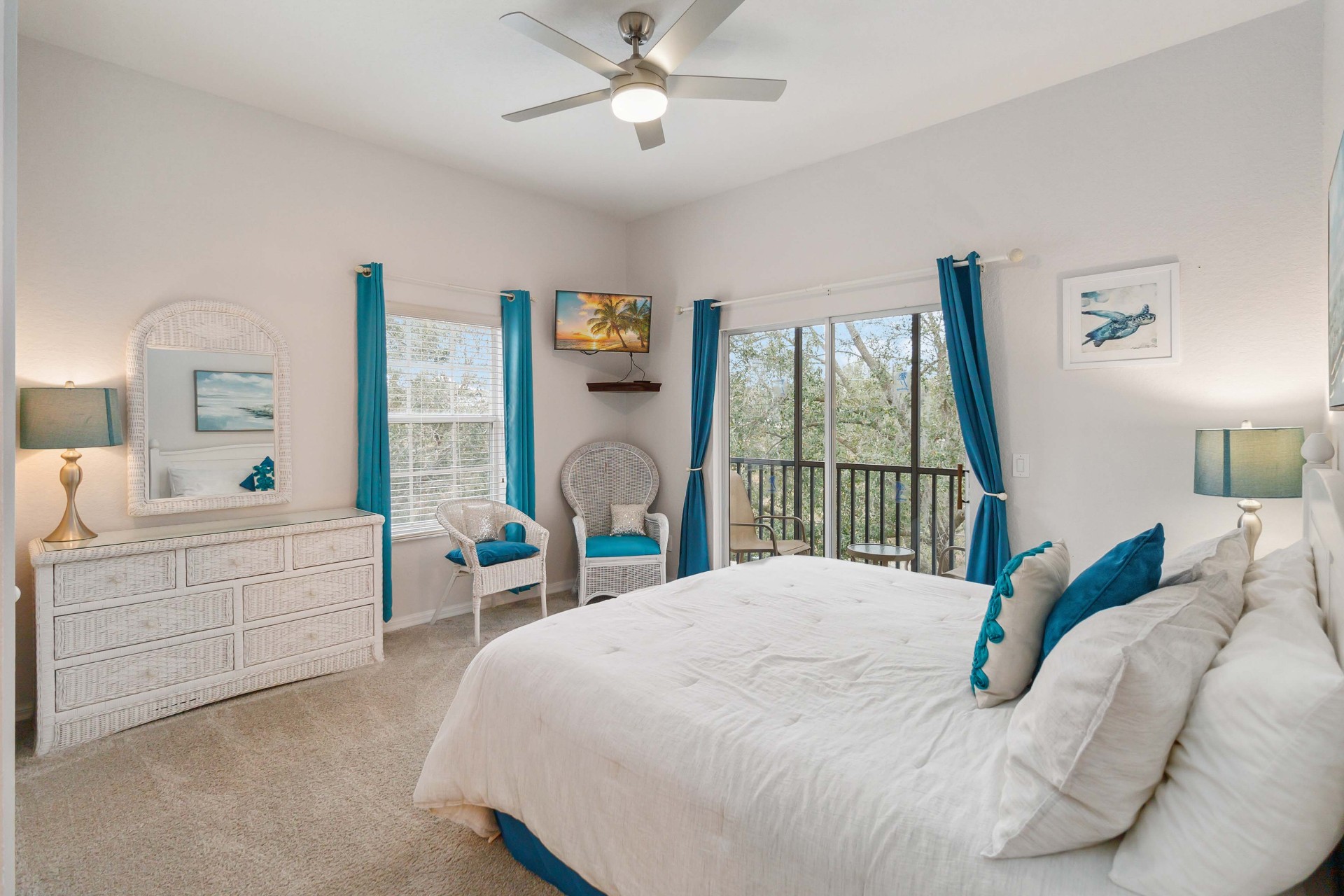 Second bedroom with teal accents and balcony view